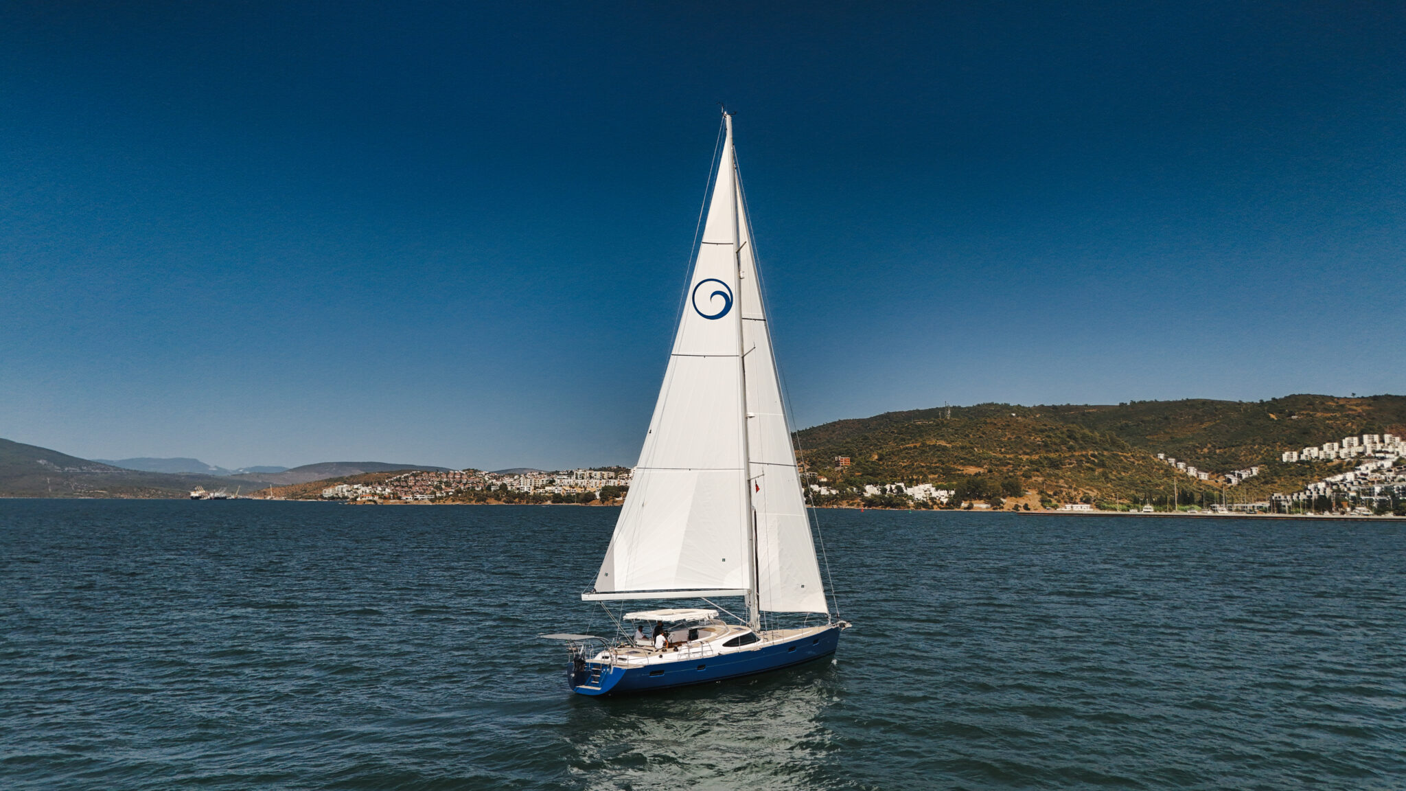 A Kraken yacht sailing along a rugged coastline